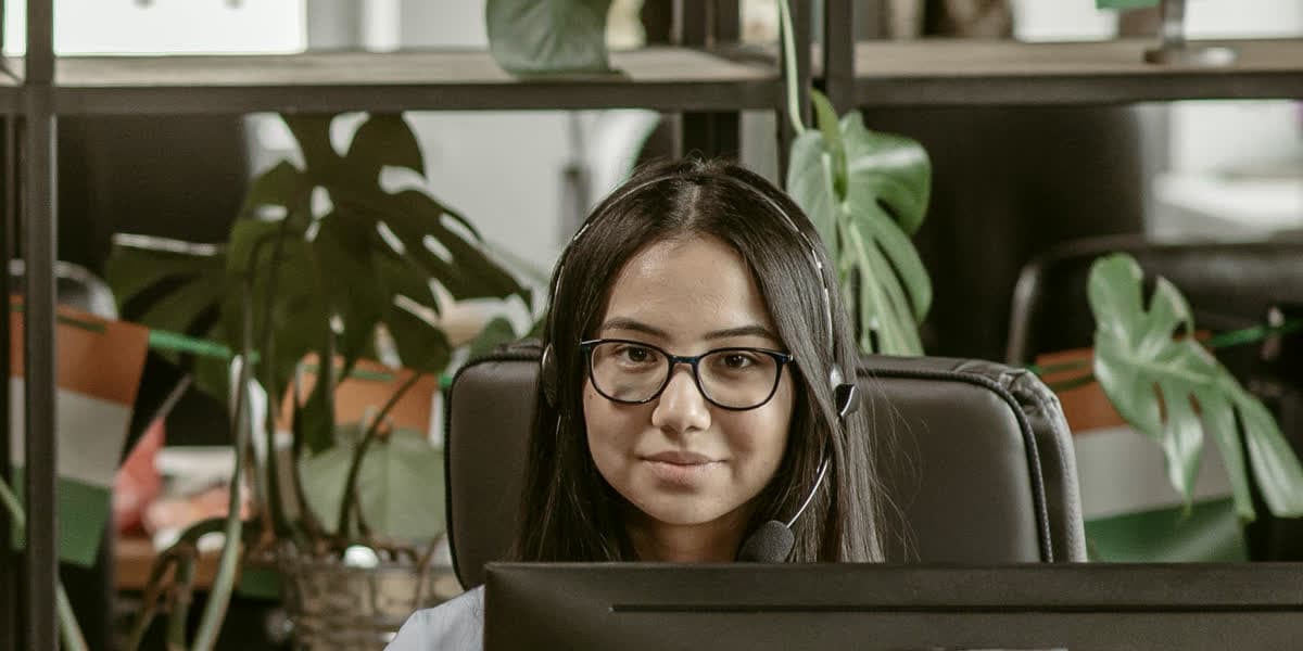 A support agent with a headset at her desk