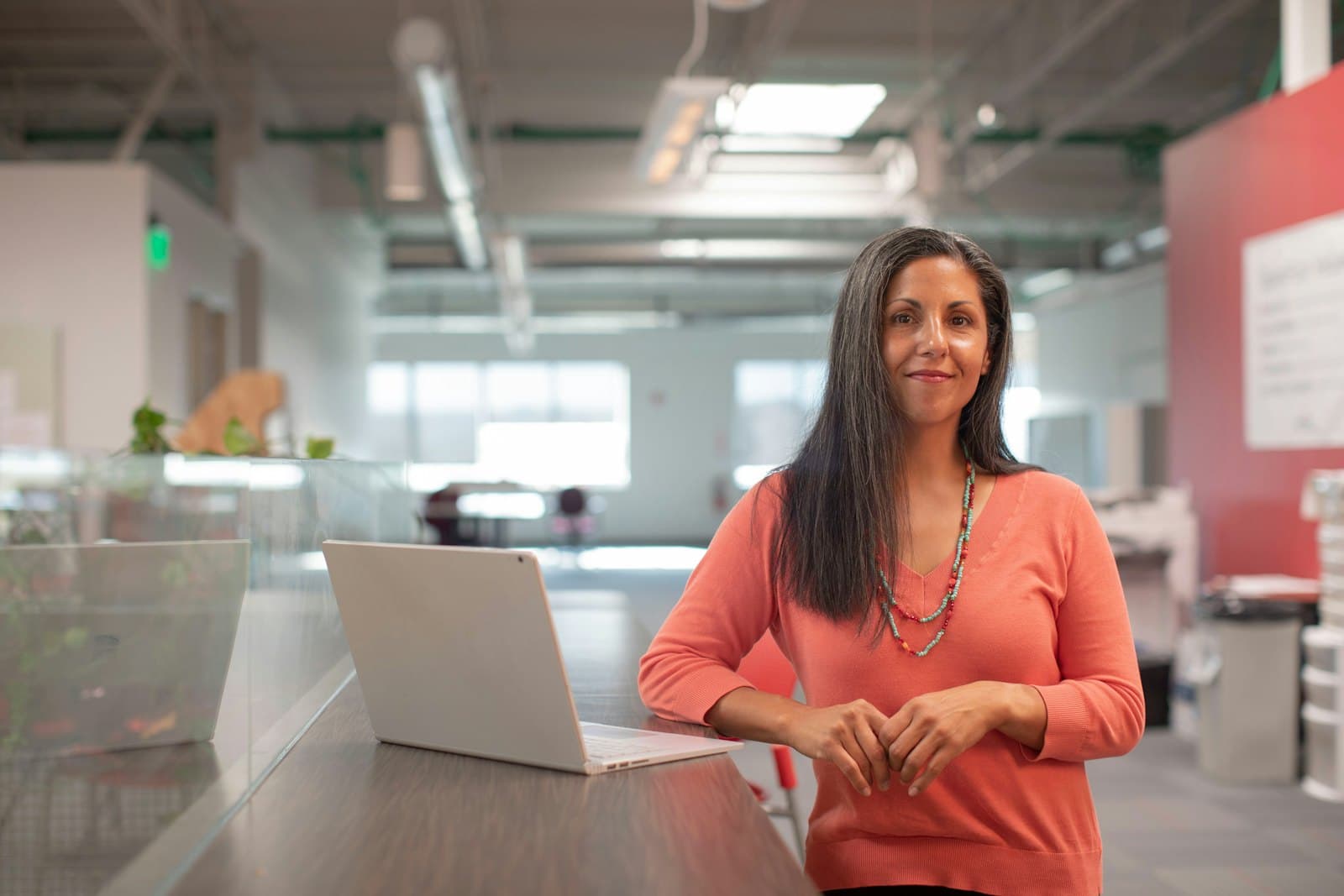 An agent working at a laptop in an open office