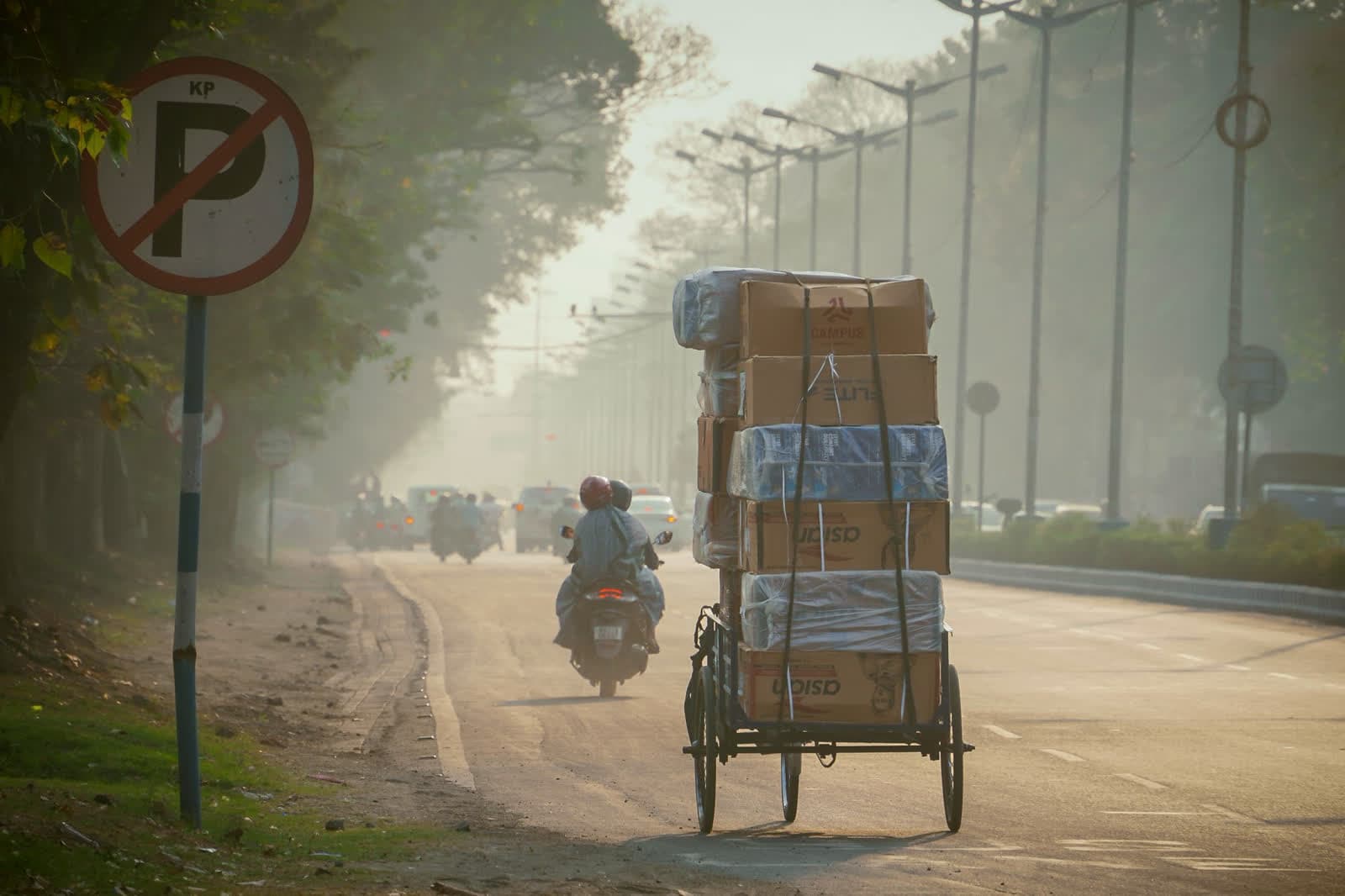 A delivery cart stacked with parcels on a city street at dawn